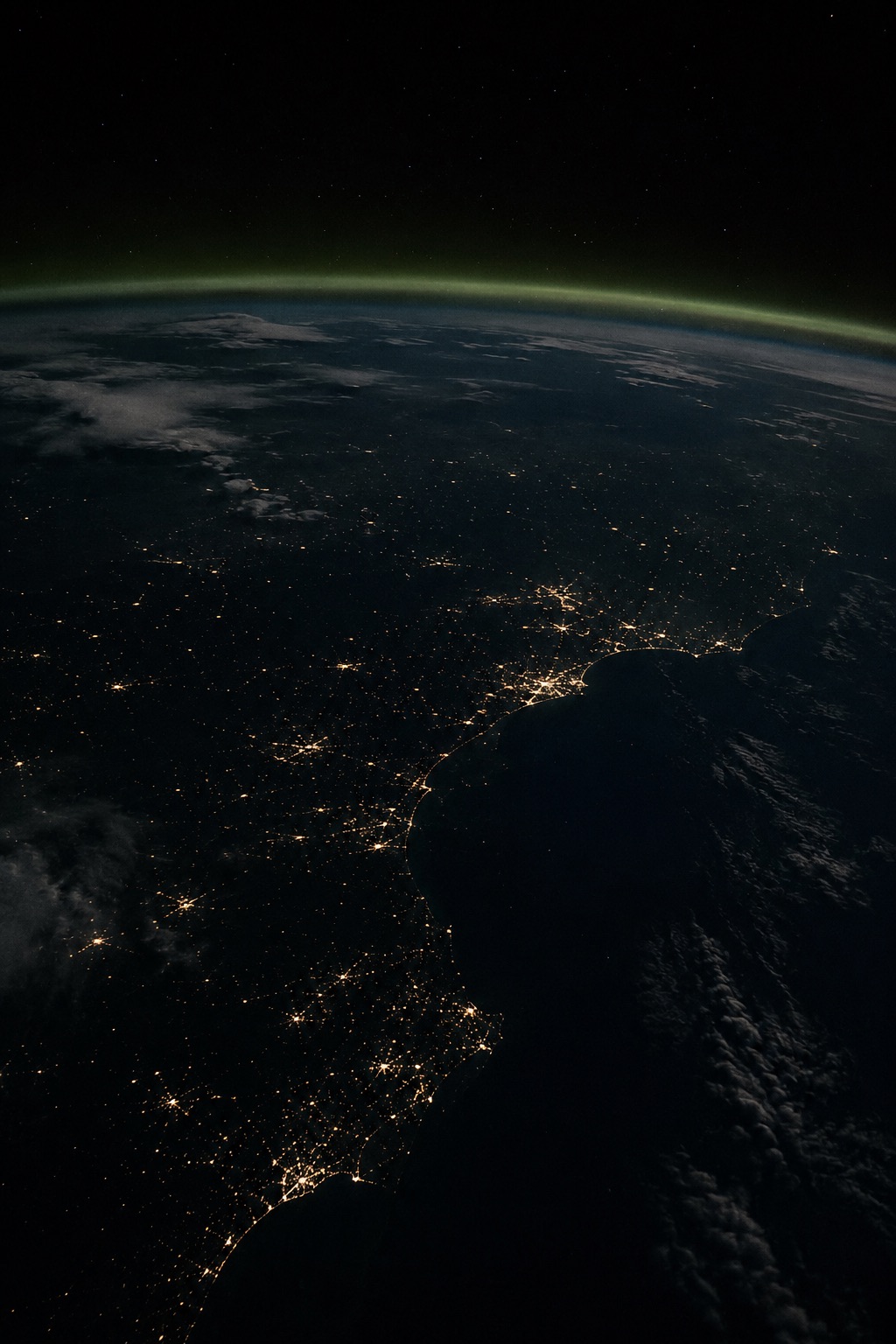 Atmospheric night view of Earth's horizon with a green airglow, symbolizing international reach